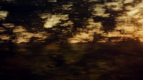 Abstract motion blur shot of golden evening sky reflections passing rapidly.. Stock Footage 345835830