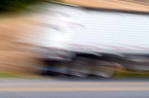 Abstract motion blur speeding tractor trailer big rig on country road Stock Photos