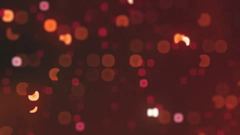 Abstract motion graphic with orange and red bokeh lights on dark background Video stock 328716698