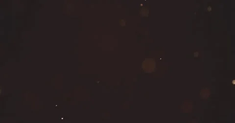 Abstract motion loop of floating golden bokeh particles on dark background Video stock 332658283