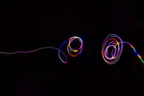 Abstract multicolored lines drawn by light on a black background 写真素材