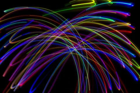 Abstract multicolored lines drawn by light on a black background 库存照片