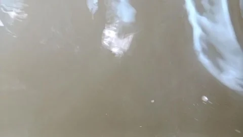 Abstract murky water surface with ripples and light reflections 库存影片 333115784