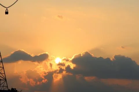 Abstract nature background. Dramatic golden hour cloudy sunset sky with sun r Stock Photos