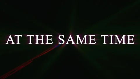 Abstract neon light streaks forming words AT THE SAME TIME in darkness with.. Stock-Footage 344032421