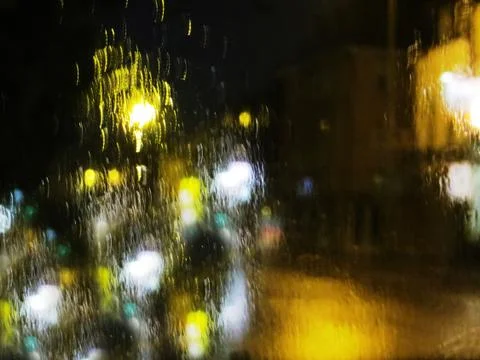 Abstract night background with rain flow and unfocused lantern light with cop Stock Photos