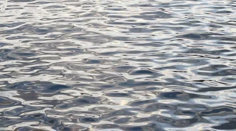 Abstract ocean ripples glimmer in the setting sun Stock Footage 922079