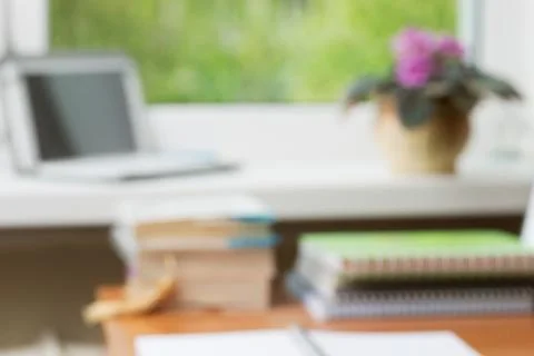 Abstract office desk table with computer, supplies, flower blur background Foto stock