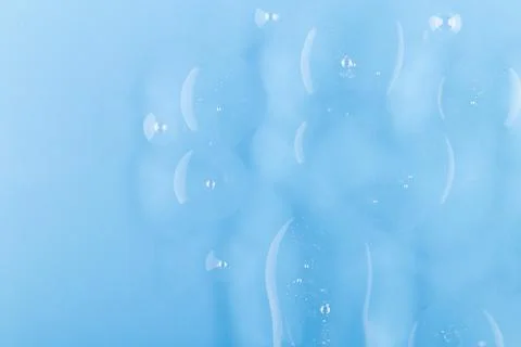 Abstract oil bubbles on blue background. Cosmetic liquid beauty product. Fa.. Stock Photos