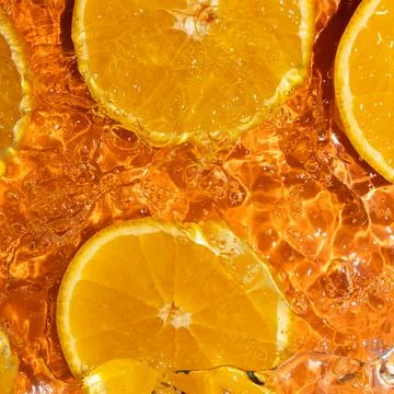 Abstract orange background, fruit in splashing water. Stock Photos