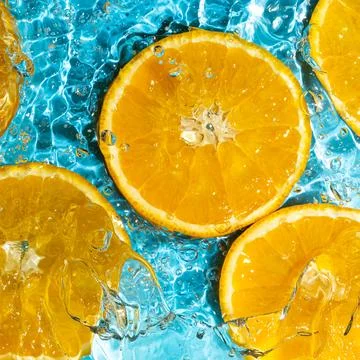 Abstract orange background, fruit in splashing water Stock Photos