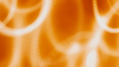 Abstract orange light patterns with circular shapes and soft focus effects Stock Photos