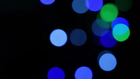 Abstract out of focus blue and green bokeh lights glowing on a black backgrou 動画素材 337898948
