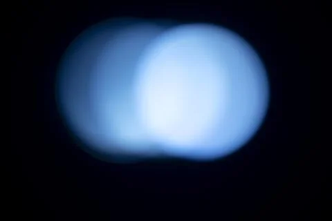 Abstract out of focus blue bokeh lights against a black background. Abstrac.. Stock Photos