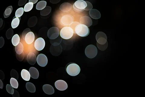 Abstract out of focus glowing lights creating a festive bokeh pattern on bl.. Stock Photos