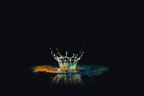 Abstract paint drop crown splash reflected against a black background. Stock Photos
