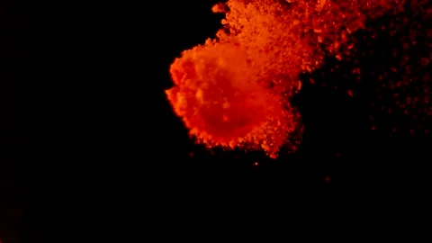 Abstract particles of red and orange liquid flow and float motion on black Stock Footage 138593406