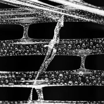 An abstract pattern of bars with foil wrap on them with water drops on a blac Stock Illustration
