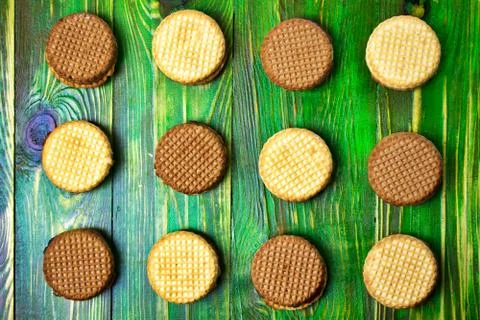 Abstract pattern of biscuits round shape on a green wooden background. Top fl Stock Photos