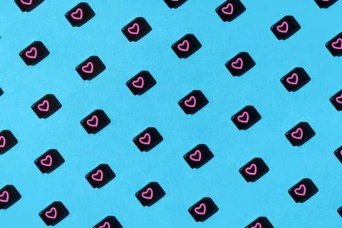 Abstract pattern of black beads with pink heart on blue background. St Stock Photos