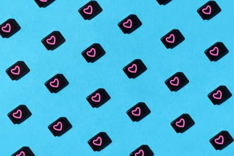 Abstract pattern of black beads with pink heart on blue background. St Stock Photos