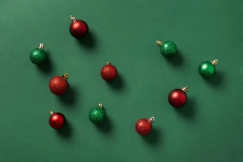 Abstract pattern of Christmas red and green balls on green. Xmas wallpaper. Stock Photos