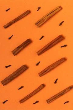 Abstract pattern with cinnamon and carnation on orange background Stock Photos