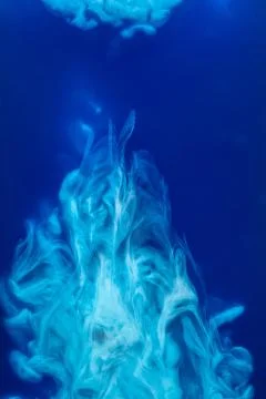 Abstract pattern falling into the water drop of blue ink - cyan ink dissolved in Stock Photos