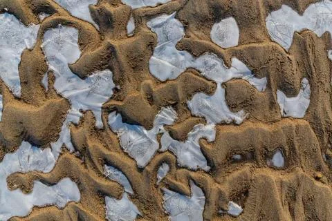 Abstract pattern with fresh snow on a sandy river beach 写真素材