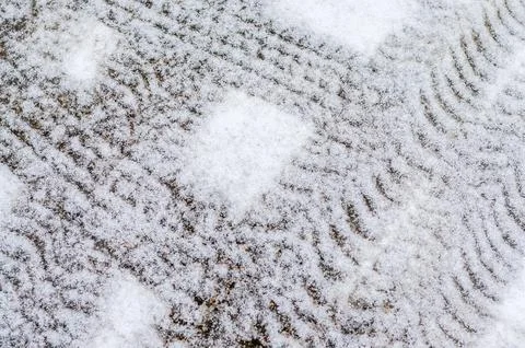 Abstract pattern of fresh white snow on paving stones outdoors. Stock Photos