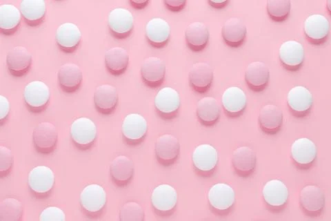 Abstract pattern of pink and white candy or pills on pastel color background Stock Photos