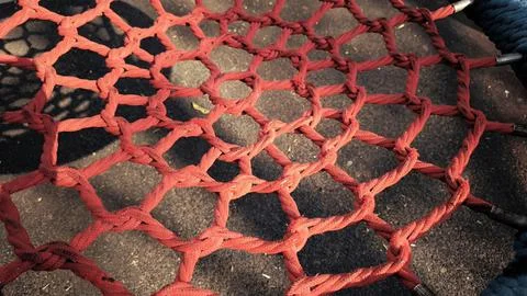Abstract pattern of red woven rope net on playground equipment. Fotos Stock