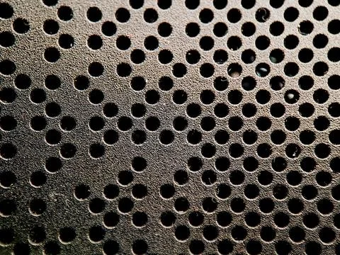 Abstract pattern reveals a black textured surface with evenly spaced circul.. Stock Photos