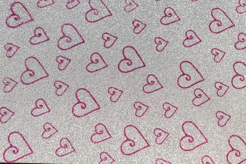 Abstract pattern of shiny red hearts on a gray background. For backgrounds, c Фото