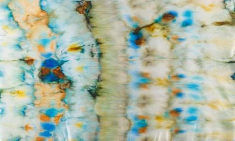 Abstract pattern on silk fabric texture in blue, yellow, green colors Stock Photos