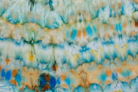 Abstract pattern on silk fabric texture in blue, yellow, green colors Stock Photos