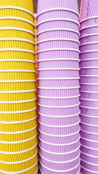 Abstract pattern of stacked yellow and purple ripple paper cups for takeawa.. Stock Photos