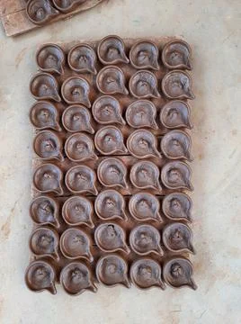 Abstract pattern texture background of wet handmade sand diya or oil lamps Stock Photos