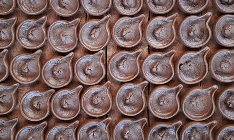 Abstract pattern texture background of wet handmade sand diya or oil lamps Stock Photos
