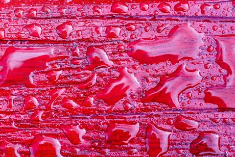 Abstract pattern of water droplets on a red painted wooden surface after rain Foto stock