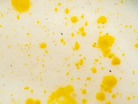 Abstract pattern of yellow paint splashes and spots on bright background. Close Stock Photos