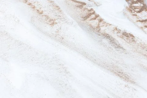 Abstract patterns of beige sand swept across white snow 写真素材