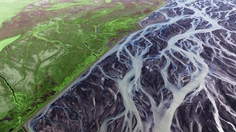 Abstract patterns of braided glacial rivers contrasting with green earth Stock Footage 339764652