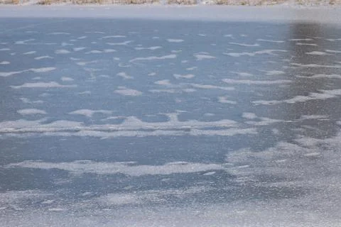 Abstract patterns of ice and snow on a frozen body of water in winter 스톡 사진