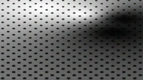 Abstract perforated metal background loop with moving shadows Stock Footage 337706038