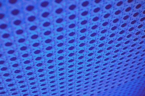 Abstract perforated wall background highlighted by blue neon led lights Stock Photos