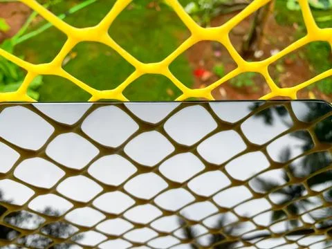 Abstract plastic net texture and his shadow on smartphone display. Stock Photos