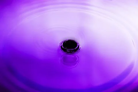 Abstract purple splash water The surface of the water spreads in glittering c Stock Photos