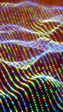 Abstract rainbow waves composed of multicolored glowing dots in a dynamic flu Stock Photos