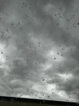Abstract Raindrops on Window Glass with Dramatic Stormy Cloudy Sky Background Stock Photos